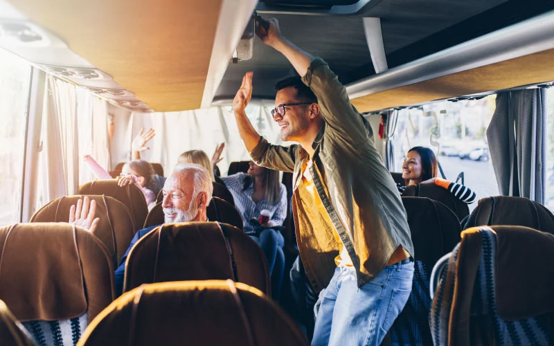 Corporate group boarding a coach from London to Brighton on a sunny holiday morning.