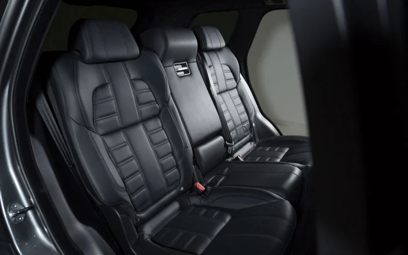 Interior of a private coach showing leather seats and conference-style layout ready for business travel.